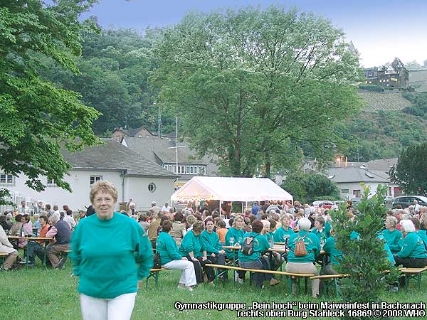 Gymnastikgruppe "Bein hoch" beim Maiweinfest in Bacharach. Rechts oben Burg Stahleck.